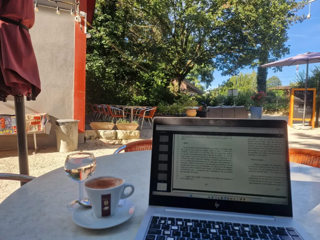 PC portable avec correction du livre à une terrasse de café